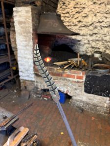 An ear of corn in metal in a forge